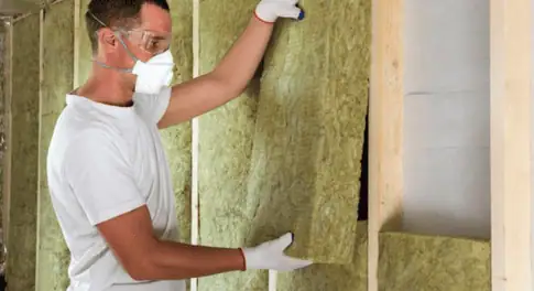 Rockwool insulation boards being installed in a wall for acoustic performance
